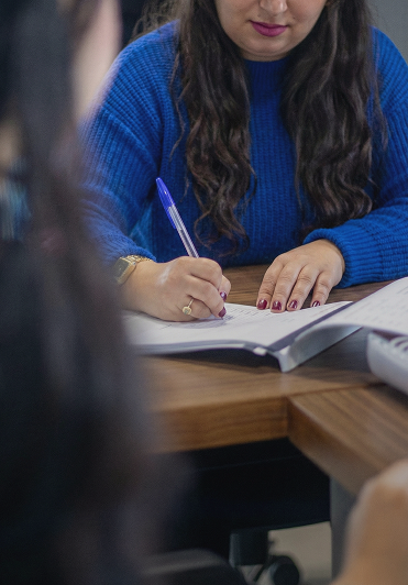 Professionnel en costume avec plans architecturaux offrant un accompagnement financier